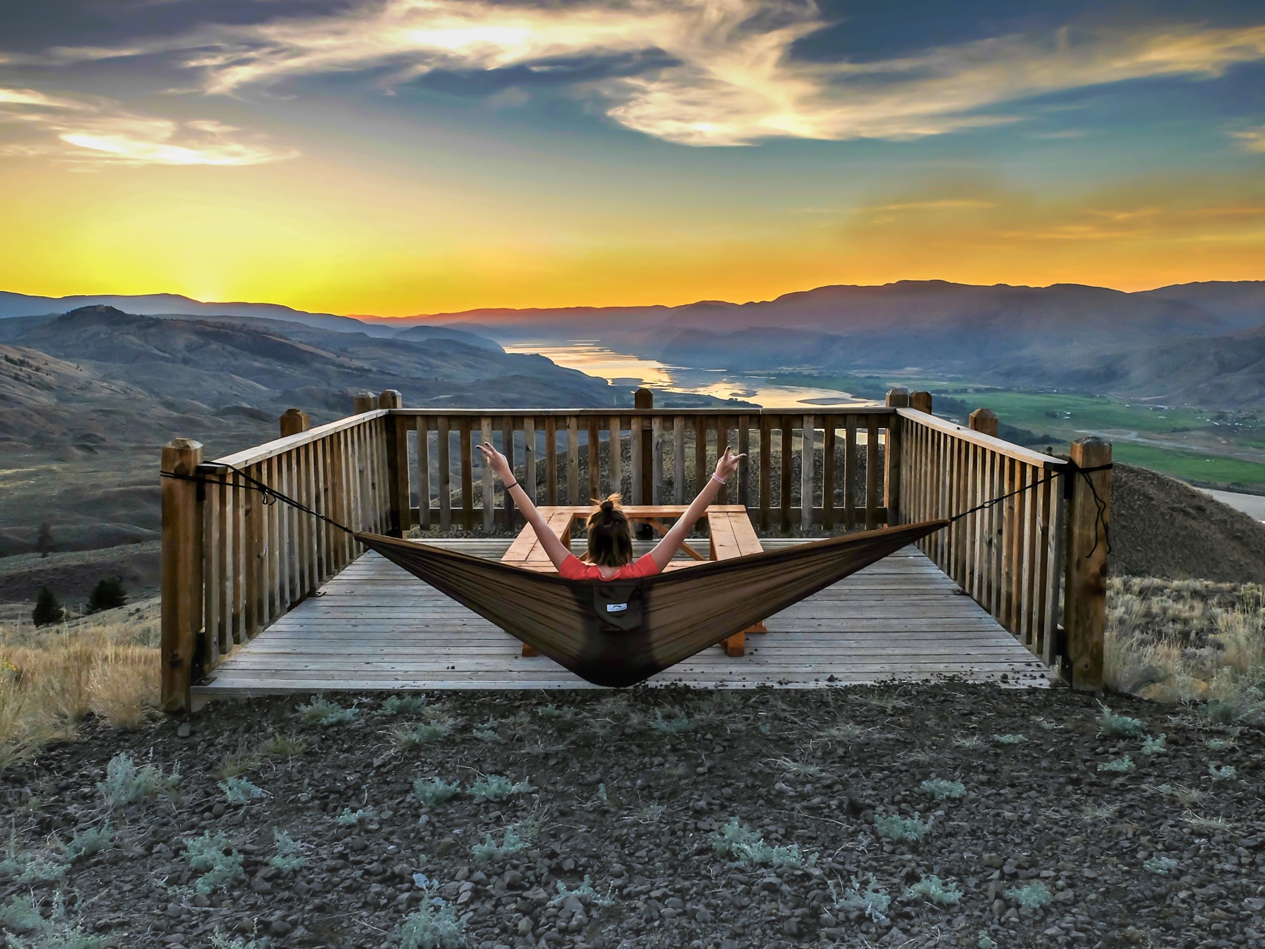 Small group hiking above Kamloops at sunset with river valley views.